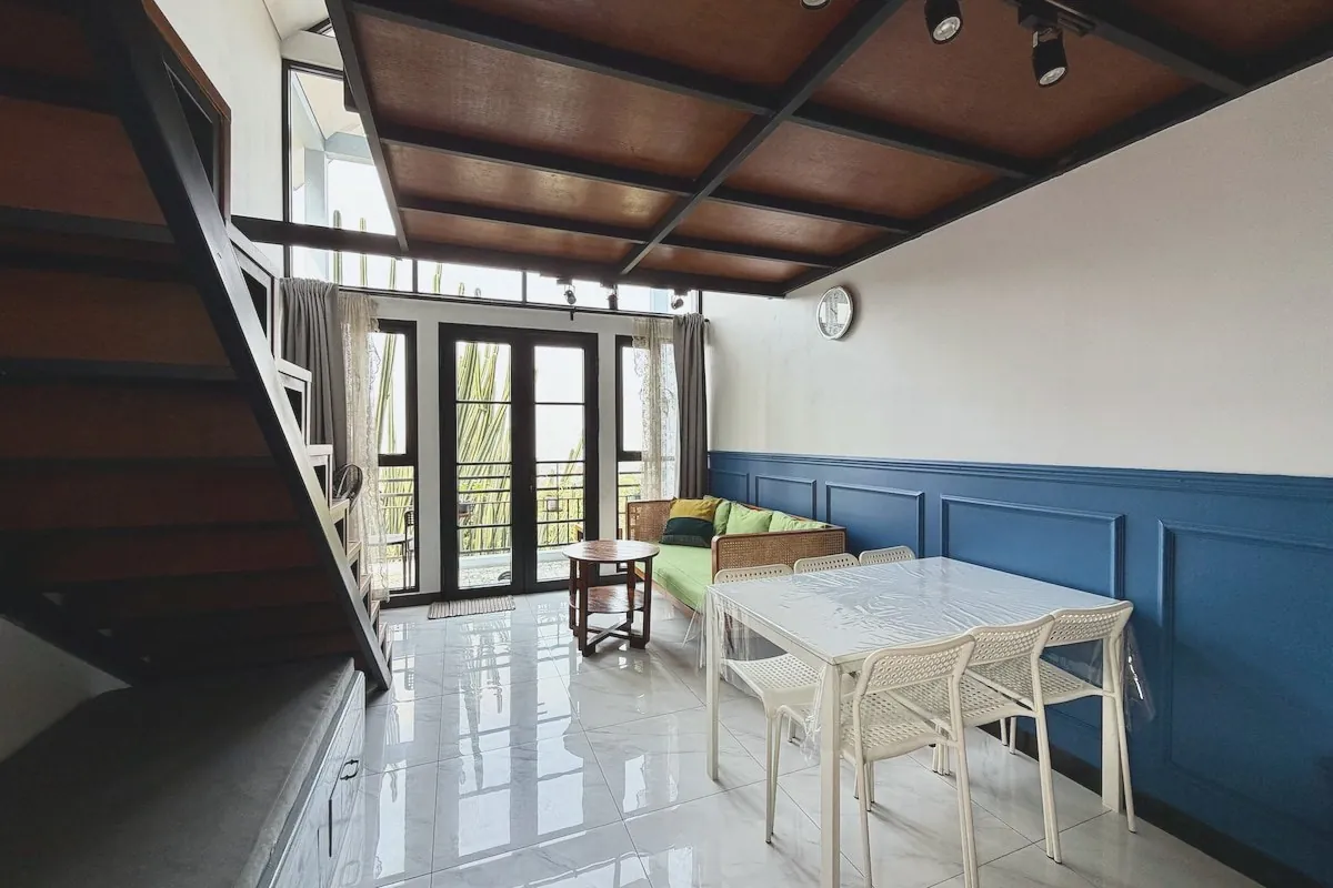 Living area with mezzanine loft above and full-height windows