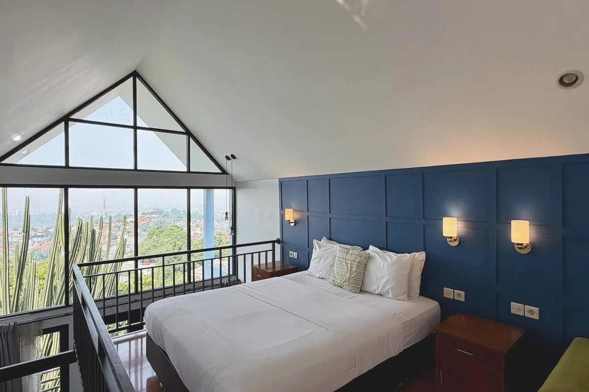 Master bedroom with queen bed and warm timber floors at House of Flowers Dago
